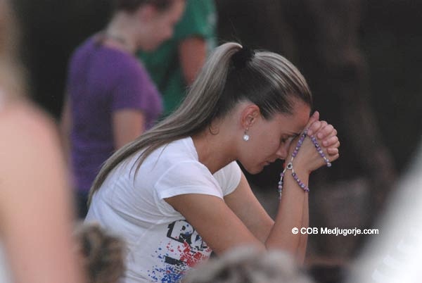 Pilgrim praying on Apparition Mountain June
                    17, 2013